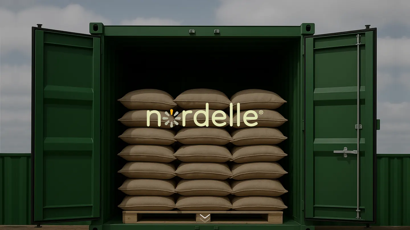 Nordelle logo over stacked raw material sacks inside an open green shipping container