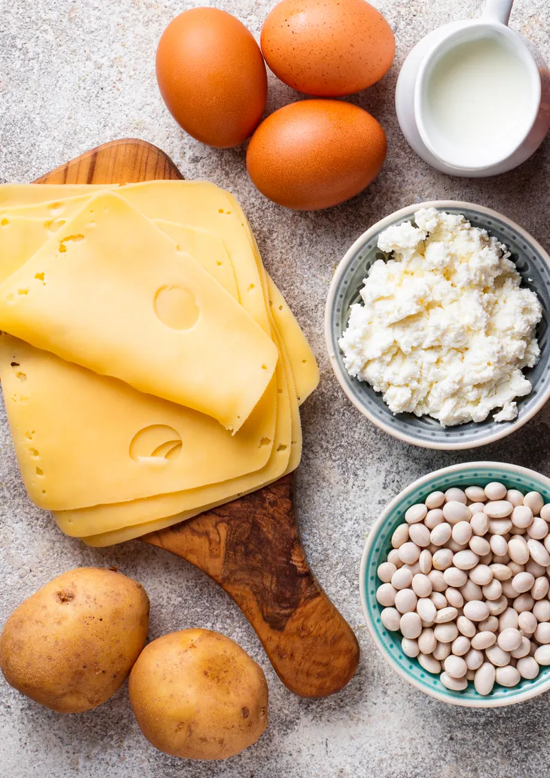 Eggs, cheese, milk, chickpeas and nuts on a wooden surface: amino acid ingredients